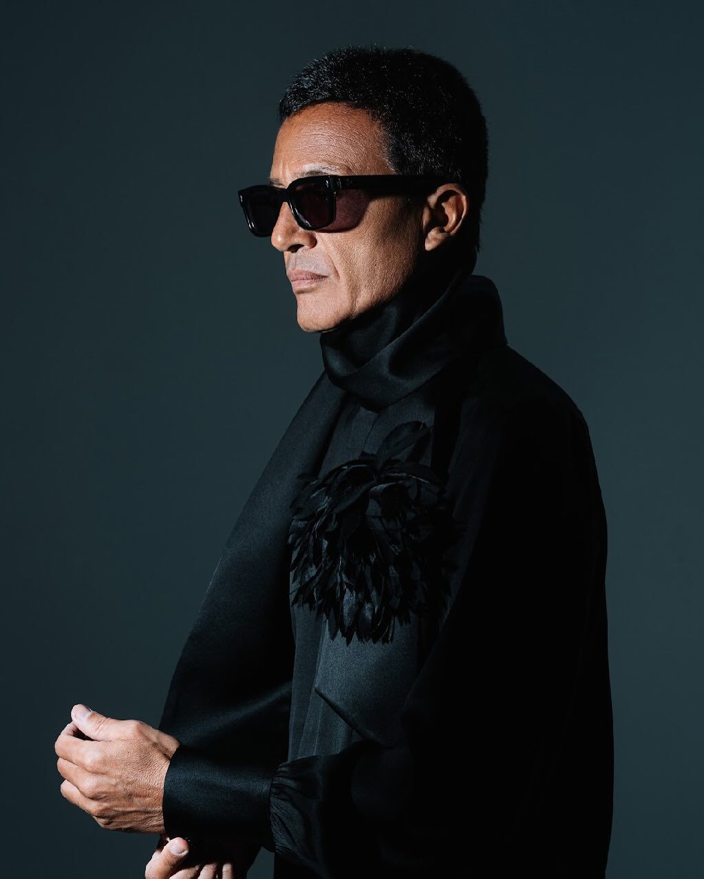 Omar Harfouch — dark editorial portrait with feather brooch